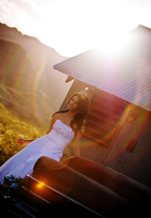 a bride poses by old farm equipment