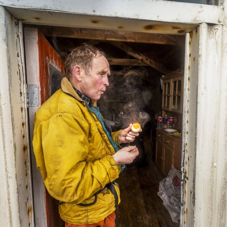 Ragnar Th Sigurdsson/Arctic-Images - Man eating fresh guillemot eggs that were collected from the cliffs a few hours prior, Ingolfshofdi, South Coast, Iceland